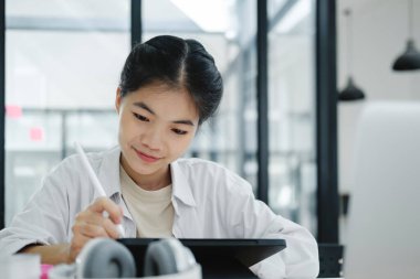 Çevrimiçi eğitim, e-öğrenme. Bilgisayar ve mobil cihaz kullanan genç bir kolaj öğrencisi. Asyalı genç öğrenci çevrimiçi öğrenim sınıfı çalışması Zoom hocası adı verilen online video eğitimi.