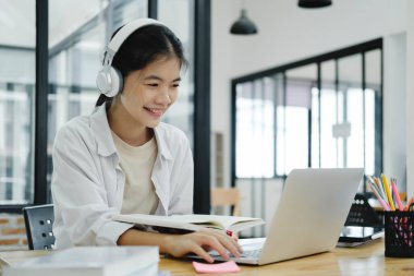 Çevrimiçi eğitim, e-öğrenme. Bilgisayar ve mobil cihaz kullanan genç bir kolaj öğrencisi. Asyalı genç öğrenci çevrimiçi öğrenim sınıfı çalışması Zoom hocası adı verilen online video eğitimi.