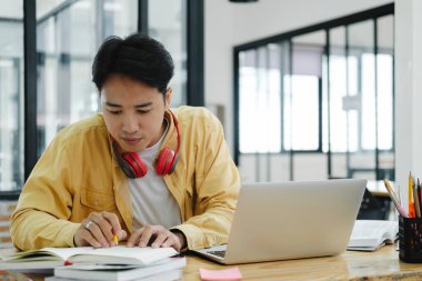 Çevrimiçi eğitim, e-öğrenme. Bilgisayar ve mobil cihaz kullanan genç bir kolaj öğrencisi. Asyalı genç öğrenci çevrimiçi öğrenim sınıfı çalışması Zoom hocası adı verilen online video eğitimi.