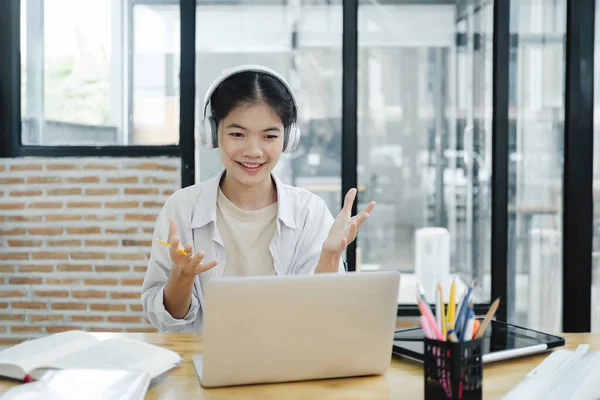 Video call online meeting. Young woman waving to his colleague and explaining and discuss her opinions during the online meeting. Online learning, online business concept.