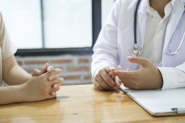 Doktor ve hasta. Doktor muayenehanesinde reçeteli hastaya teşhis koymayı ve tedavi planlarını tartışmayı bitirin. Tıbbi ve sağlık hizmetleri kavramı.