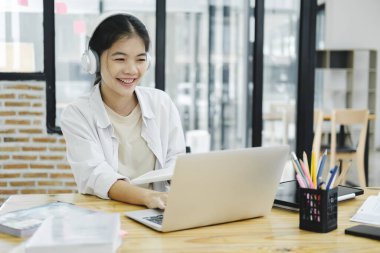 Çevrimiçi eğitim, e-öğrenme. Bilgisayar ve mobil cihaz kullanan genç bir kolaj öğrencisi. Asyalı genç öğrenci çevrimiçi öğrenim sınıfı çalışması Zoom hocası adı verilen online video eğitimi.