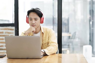 Çevrimiçi eğitim, e-öğrenme. Bilgisayar ve mobil cihaz kullanan genç bir kolaj öğrencisi. Asyalı genç öğrenci çevrimiçi öğrenim sınıfı çalışması Zoom hocası adı verilen online video eğitimi.