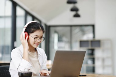 Çevrimiçi eğitim, e-öğrenme. Bilgisayar ve mobil cihaz kullanan genç bir kolaj öğrencisi. Asyalı genç öğrenci çevrimiçi öğrenim sınıfı çalışması Zoom hocası adı verilen online video eğitimi.