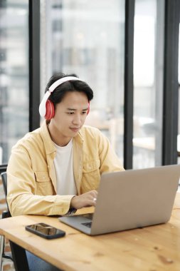 Çevrimiçi eğitim, e-öğrenme. Bilgisayar ve mobil cihaz kullanan genç bir kolaj öğrencisi. Asyalı genç öğrenci çevrimiçi öğrenim sınıfı çalışması Zoom hocası adı verilen online video eğitimi.