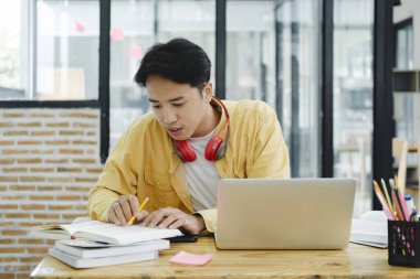 Çevrimiçi eğitim, e-öğrenme. Bilgisayar ve mobil cihaz kullanan genç bir kolaj öğrencisi. Asyalı genç öğrenci çevrimiçi öğrenim sınıfı çalışması Zoom hocası adı verilen online video eğitimi.