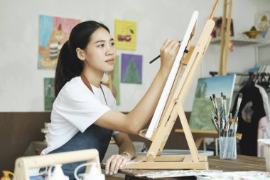 Genç kadın sanatçı, bir stüdyo atölyesinde resmini tuvale çizer ya da boyar. Sanattan ve çizimden hoşlanan genç bir kız suluboyalarını büyük bir niyetle tuvalde yapıyor.