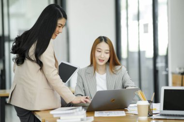 Çalışan kadınlar iş hakkında konuşuyor ve iş arkadaşlarıyla fikir alışverişinde bulunarak yeni iş planları planlıyorlar..