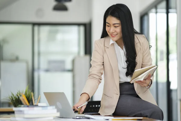 Focused Businesswoman Working Laptop While Holding Notebook Bright Office Environment — Stock Photo, Image