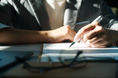 Bir kadın bir kağıt parçasına kalemle yazıyor. Kadın dikkatlice yazarken odaklanma ve konsantrasyon kavramı