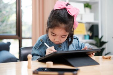 Bir ilkokul öğrencisi uzaktan kumandayla bir robotik kolu çalıştırmaya odaklanarak BTMM eğitimini iş başında gösteriyor..