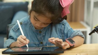 Eğitimde teknolojiyi kucaklayan, dijital tablet üzerine resim çizmek için stilus kalem kullanan, kot giymiş konsantre genç bir kız..
