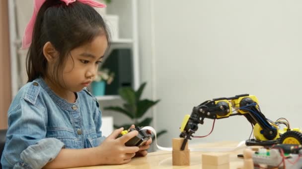 小学校の少女は 遠隔操作でロボットアームを操作することに焦点を当て Stem教育を実証する — ストック動画