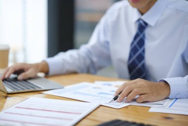 İnternette çalışan işadamı ya da muhasebeci, yatırımları, riskleri, vergileri ve ofis masasındaki bütçeleri analiz etmek için dizüstü bilgisayar kullanıyor..