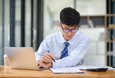 Bir işadamı hisse senedi performansı, yatırım sonuçları veya vergi ve bütçe bilgilerini gösteren grafiklerden elde edilen risk, yatırım ve pazar verilerini analiz eder.