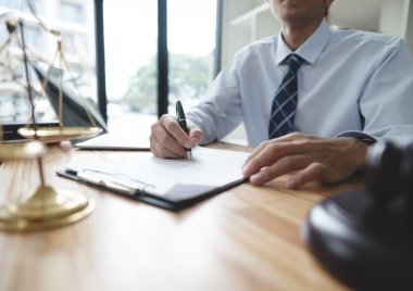 Bir avukat ya da işadamı büro masasında önemli belgeler imzalıyor. Görüntü, karar verme ve yetki odaklı yasal veya mali evrakları inceleyen bir profesyoneli yakalıyor..