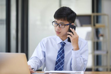 Güvenilir iş adamı, iş ortağıyla telefonda yaptığı sözleşmenin detaylarını gözden geçiriyor..