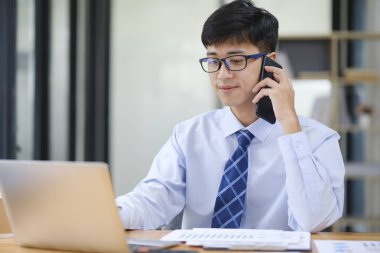 Güvenilir iş adamı, iş ortağıyla telefonda yaptığı sözleşmenin detaylarını gözden geçiriyor..