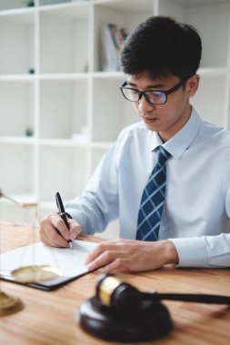 Bir avukat ya da işadamı büro masasında önemli belgeler imzalıyor. Görüntü, karar verme ve yetki odaklı yasal veya mali evrakları inceleyen bir profesyoneli yakalıyor..
