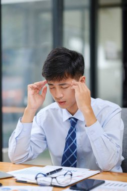 Genç Asyalı iş adamı ve bilgisayarlarda yorgunluk, baş ağrısı ve yorgunluk için göz yorgunluğu. Hüsrana uğramış, fazla çalışan ve acı çeken, fazla mesai yapan ve tükenmiş çalışanların teknolojisi..