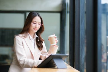 Bir iş kadını not almak, veri analizi, e-imzalar ve tasarım için tablet ve dijital kalem kullanır. Görüntü, üretkenlik, verimlilik ve mesleki görevler için modern araçları vurgular.