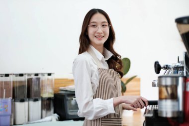 Kahveyi hazırlamak için espresso makinesi kullanan bir barista hassasiyet ve uzmanlık gösteriyor. Sahne, modern bir kafe işinde gerekli olan profesyonellik ve ayrıntılara dikkat çekiyor.