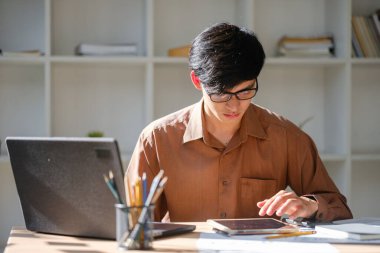 Bir işadamı ya da öğrenci, mali raporları ve verileri incelerken çevrimiçi çalışır. Stratejik planlama, yatırım ve bilgi ve karar verme becerilerini geliştirmeye odaklanıyor..