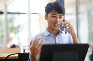 Akıllı telefon ve tabletle birden fazla iş yapan bir işletme danışmanı, mali stratejiler, yatırım planlaması veya uzaktan çalışırken iş danışmanlığı hakkında bir tartışmaya girişir..