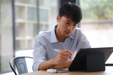 Yatırım verilerini gözden geçirmek ve müşteriler için stratejik iş planları geliştirmek için tablet kullanan bir iş danışmanı, mali analize odaklandı..