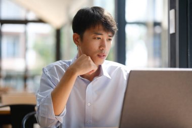 Dizüstü bilgisayarda çalışan bir iş adamı, finansal analiz, yatırım planlaması ya da iş danışmanlığı yapıyor. Çevrimiçi iş, muhasebe veya strateji geliştirme için teknoloji kullanılıyor.