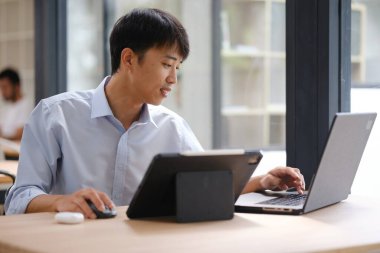 Dizüstü bilgisayarda çalışan bir iş adamı, finansal analiz, yatırım planlaması ya da iş danışmanlığı yapıyor. Çevrimiçi iş, muhasebe veya strateji geliştirme için teknoloji kullanılıyor.