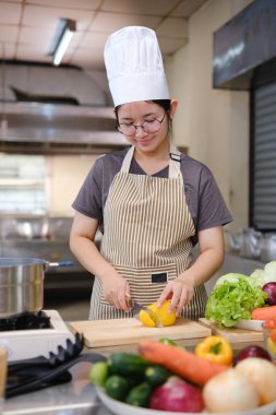Sağlıklı ve besleyici bir öğle yemeği hazırlamak: Mutfakta sebze doğrayan bir aşçının elleri