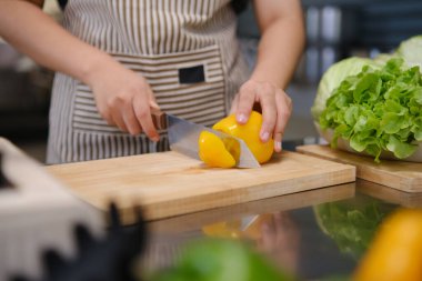 Sağlıklı ve besleyici bir öğle yemeği hazırlamak: Mutfakta sebze doğrayan bir aşçının elleri