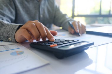 İş adamı veya muhasebeci mali yatırım hesap makinesi hesaplamak analiz iş ve Pazar büyüme mali belge veri grafiği ve yazma, muhasebe, ekonomik, ticari ile çalışma