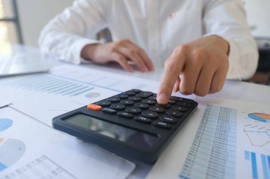 İş adamı veya muhasebeci mali yatırım hesap makinesi hesaplamak analiz iş ve Pazar büyüme mali belge veri grafiği ve yazma, muhasebe, ekonomik, ticari ile çalışma