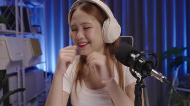 Modern kapalı bir stüdyoda canlı yayında canlı yayında izleyicilerin sorularını dikkatle dinleyen podcast sunucusunun medyumu.