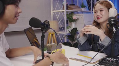 Bir podcast sunucusu, bir ev stüdyosu ortamında gülümseyen ve anlamlı bir sohbete girişen bir misafirle canlı bir tartışmayı yönetiyor..