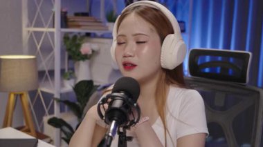 Podcast sunucusu çevrimiçi yayın ve otantik iletişimi temsil eden canlı kayıt sırasında mikrofona konuşuyor.