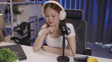 Bir podcast sunucusu bir dinleyiciyi dinler ve program sırasında etkileşim ve bağlılıkla yanıt verir..