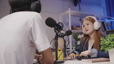 Bir podcast konuğu sunucuyla ilgili bir tartışmayı dinlerken duygularını gösterir.