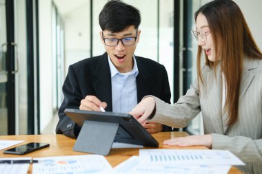 İki işadamı mali raporları birlikte inceledikten sonra başarılı sonuçları kutluyor