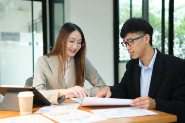 İki profesyonel mali tabloları gözden geçirir ve takım toplantısında yatırım stratejisini tartışır.