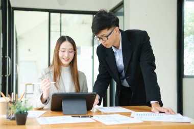 İki profesyonel mali tabloları gözden geçirir ve takım toplantısında yatırım stratejisini tartışır.