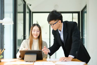 İki profesyonel mali tabloları gözden geçirir ve takım toplantısında yatırım stratejisini tartışır.