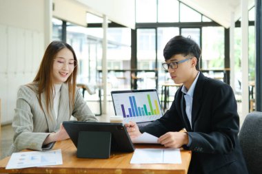 İki profesyonel mali tabloları gözden geçirir ve takım toplantısında yatırım stratejisini tartışır.
