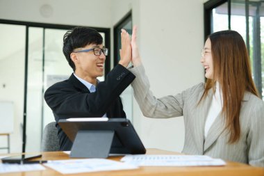 İki işadamı mali raporları birlikte inceledikten sonra başarılı sonuçları kutluyor