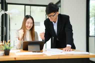 İki işadamı mali raporları birlikte inceledikten sonra başarılı sonuçları kutluyor