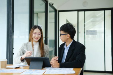 İki profesyonel mali tabloları gözden geçirir ve takım toplantısında yatırım stratejisini tartışır.