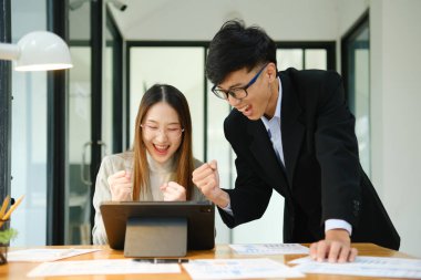 İki işadamı mali raporları birlikte inceledikten sonra başarılı sonuçları kutluyor