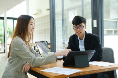 İki profesyonel mali tabloları gözden geçirir ve takım toplantısında yatırım stratejisini tartışır.
